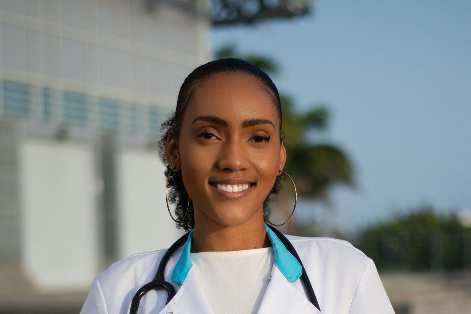 Portrait souriant d'une professionnelle de santé en blouse blanche avec stéthoscope